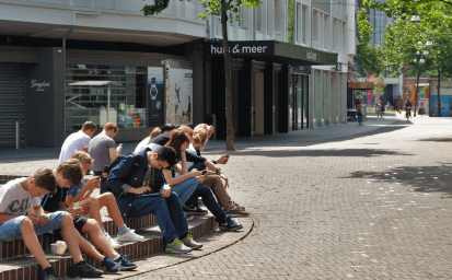 Teenagers sitting together on steps in a city square